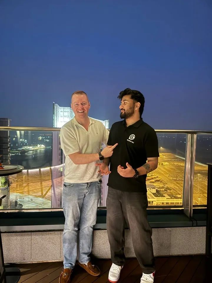 tanishq bodh on a rooftop at night with the city lit up behind him
